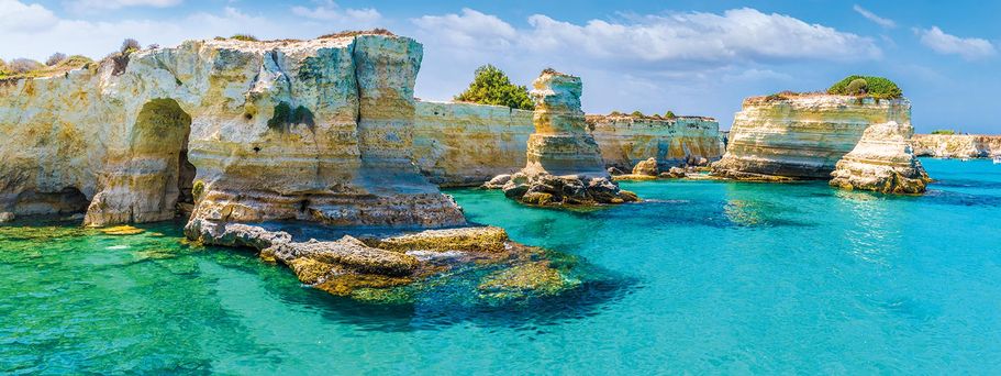 Eine Bucht mitten im türkisblauen Meer, umgeben von imposanten Felsen.