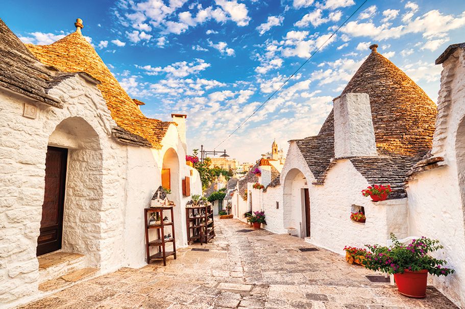 Eine Straße voller weißer Alberobello-Häuser.